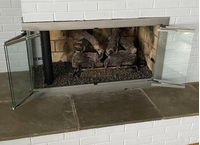 Brookfield Masonry Corner Fireplace in Silver Powder Coat Finish with Clear Tempered Glass and Trackless BiFold Doors Open