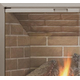 Corner detail of Huntress glass fireplace door with anodized Brushed Brass finish